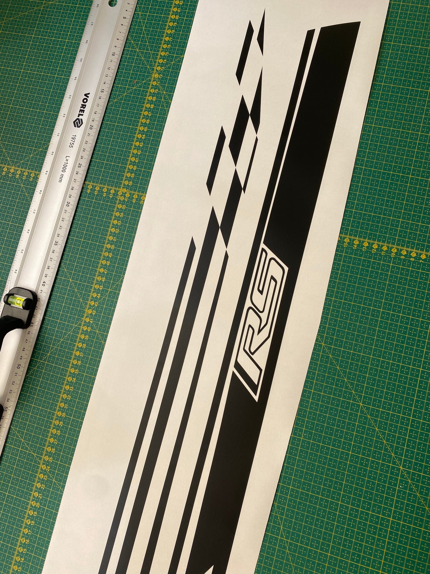 A set of black, white, and gray checkered vinyl stickers for Chevrolet Trax, displayed next to a ruler for scale.