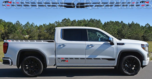 A white GMC Sierra truck with a premium vinyl sticker featuring a rocket design on the side.