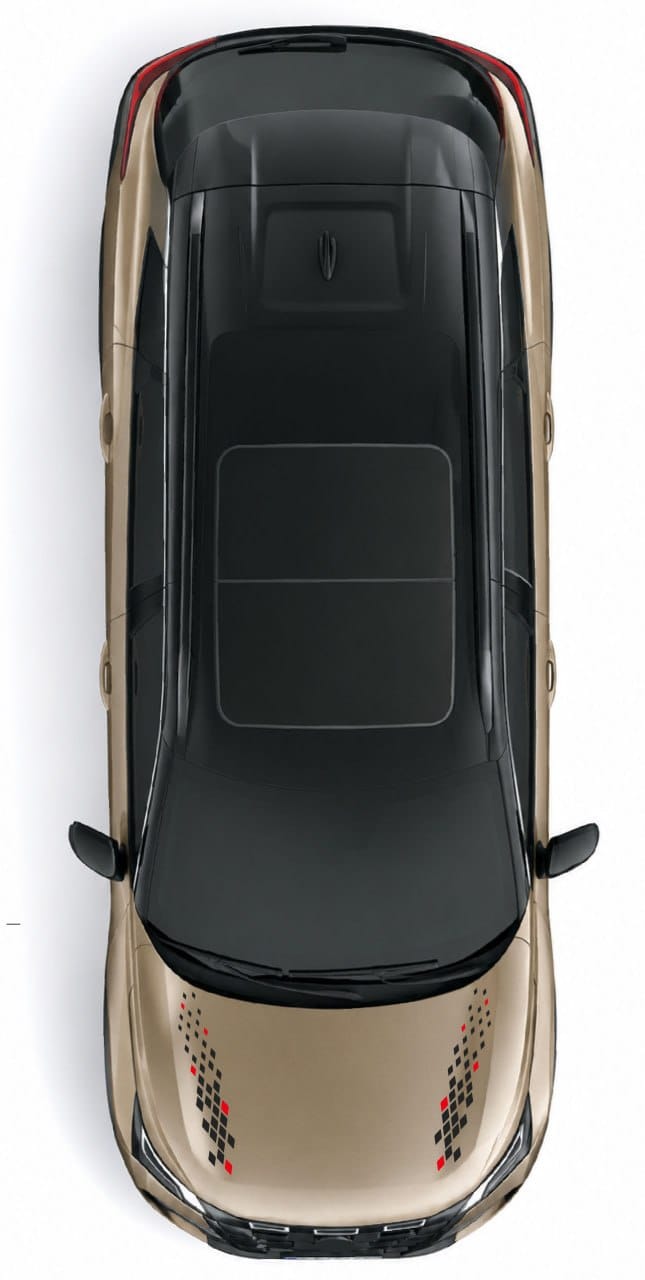Top-down view of a metallic champagne-gold car with a black roof and decorative red and black checkered decals on the hood, set against a plain white background.