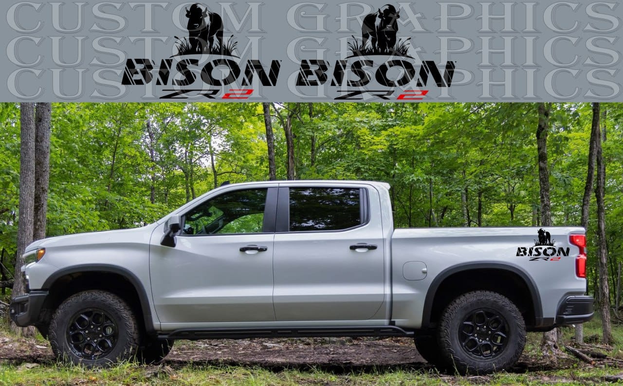 A silver Chevrolet Silverado ZR2 Bison with custom vinyl stickers and decals on it, placed in a natural outdoor setting.