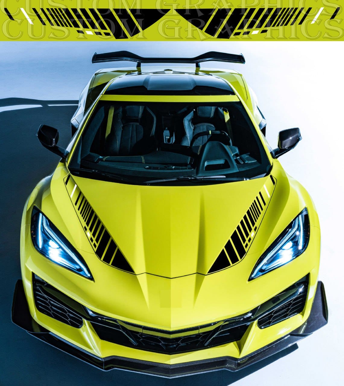 A yellow Chevrolet Corvette Z06 with black vinyl stickers on the hood.